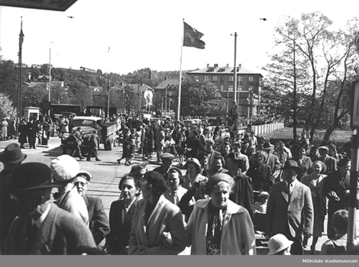 Publik inför Kung Gustav VI Adolfs (1882 - 1973) besök, som inviger och firar Gunnebo slott den 16 maj 1952 i Mölndals centrum. I bakgrunden ses järnvägsövergången på Kvarnbygatan i Mölndalsbro.