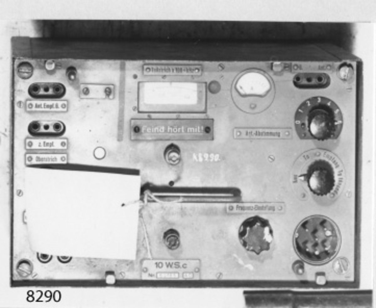 Sändare, 10W, UK-, typ 10W SC. Inbyggd i ett plåthölje. På översidan amperemätare, rattar, uttag för antenn, mikrofon m.m. Svart- och gråmålad Märkt: 10W SC Nr 69185 40.