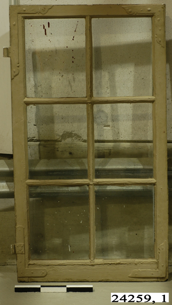 Spröjsat fönster med sex fönster inom brunmålad ram av trä. Vitmålad insida. På insidan sitter en hasp.