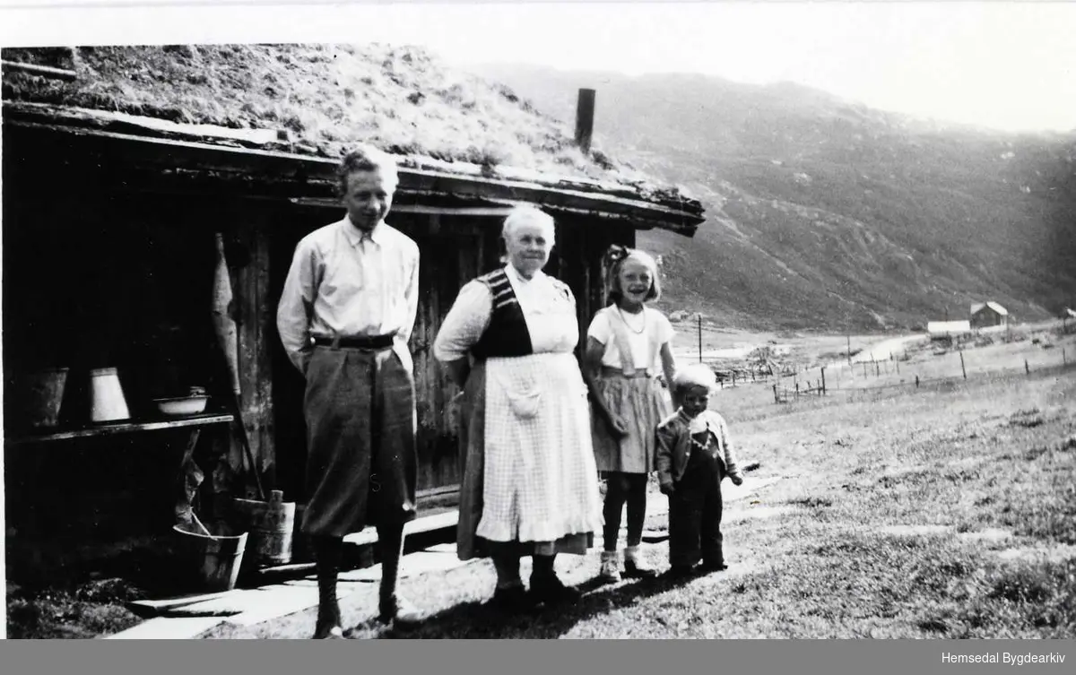 Frå venstre: ein bykar, Maria Fekene, Ukjend og Engebret Ole Fekene Noko usikkert) i Storeskar i Hemsedal i 1959.