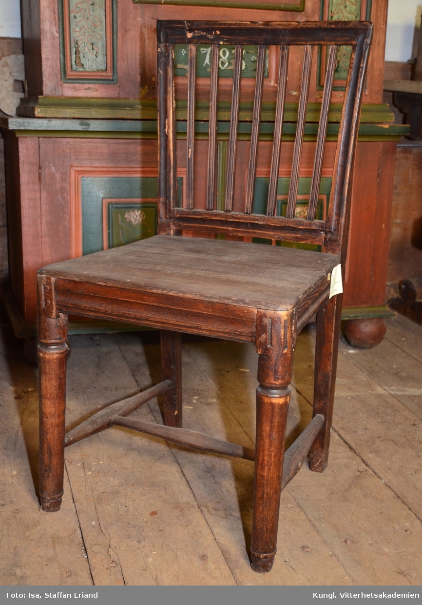 Stol, furu, brunbetsad, ryggbricka. Träsits, fästad vid stolssargen med träpluggar. Gustaviansk stil 

 fr.Hälsingland
