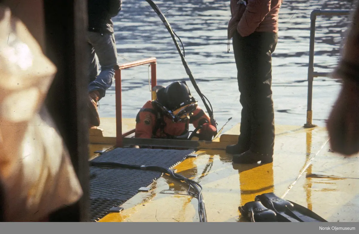Dykker på vei ned i sjøen fra "Sirafjord" for å arbeider med det første forsøket på å snu Alexander L. Kielland. 