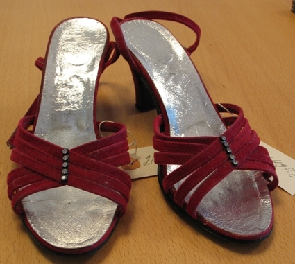 Ett par damskor av röd mocca med silverfärgad sula. Skorna är öppna och endast sex korslagda 
band går över foten . I dessa bands skärning sitter fem smyckestenar, 0,3 cm. diam. , på rad .  Vid hälen fästes skon med en moccaren vilken går runt vristen.


Skorna inköptes trol. i USA omkr. 1983-84.

21 427:a Höger sko.

:b Vänster sko.

Givaren, Eva-Karin Öberg har skänkt föremålet genom Ann-Charlott Öberg, RMVG.