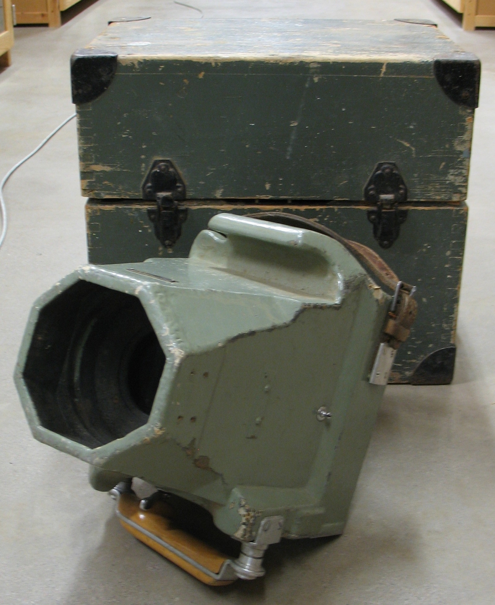 Flygkamera av modell HK-1A med en brännvidd av 24,98 cm. Kameran har en stomme av alluminium och trä som är klädd med väv samt målad i grågrön färg. Övriga delar är metall utom två handtag, ett av trä och ett av läder. Kameran förvaras i en grönmålad trälåda med måtten, H. 40 cm.  L. 44 cm.  B. 34 cm. Lådan har järnklädda hörn samt ett handtag av järn på varje kortsida. På ena kortsidan finns dessutom en skadad fraktgodssedel.


Ingår i flygfotoutrustning som inköpts av AB Flygtrafik, Steneby, Baldersnäs samt Olle Lilljeqvist Konstförlag i Bengtsfors. Företaget AB Flygtrafik var verksamt åren 1931 - 1996 och dess huvudsakliga verksamhet inriktades på flygfotografering och vykortsutgivning. Flygfotograferingen utfördes över hela landet. I samband med att Sveriges länsmuseer inköpte den omfattande samlingen av flygfotonegativ och fördelade dessa länsvis inköpte Älvsborgs länsmuseum även denna utrustning. Inköpspriset på hela utrustningen, inklusive delar av negativmaterialet var 12.000 kronor.


För ytterligare information om AB Flygtrafiks verksamhet se katalogbilaga.