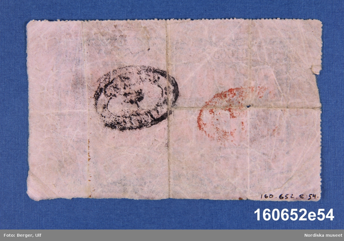 Sedel utgiven av La Republique d'Haiti, 1 gourde. Enligt lagen från den 16 april 1827, nr 81665 serie R1.
Anm.: Två ovala stämplar på baksidan, en svart och en röd.