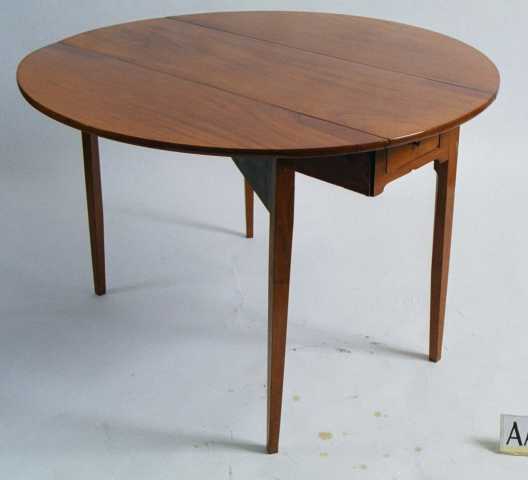 Klaffebord, av mahogny,  polert.  Bredt klaffebord med rundede klaffer.  En skuff med messingknott i hver ende. Rette ben.