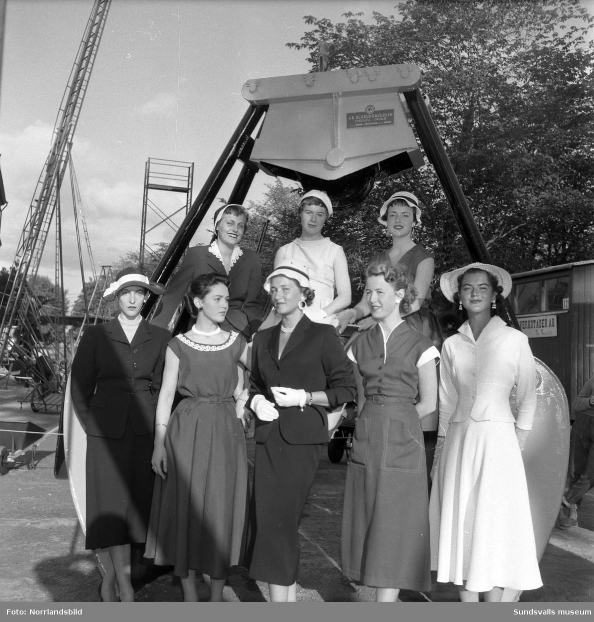 WI-BE-verken (Njurundaverken ?). Monter på Sundsvallsmässan 1954 med massor av höga stegar, samt en parad av vackra damer.