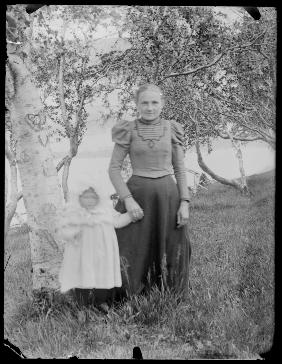 Vilhelmine Gunhild Methi med en liten jente stående ute ved bjørketre med hjerte i barken