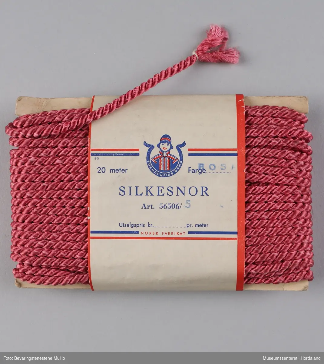 Ein pakke rosa silkesnor frå Trengereid Fabrikker i Bergen, i uopna emballasje. 

"Nylonbånd - Like velegnet som trekke- og pyntebånd til f.eks. babyplagg. Kan også brukes som dekorasjonsbånd."