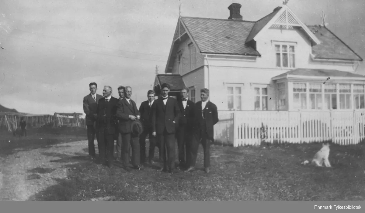 8 menn i dress er samlet til fotografering utenfor Guldbrandsenhuset i 1928.  Fra v. Sevalders, Hendry, ukj, ukj, Trygg, Pastor Torp, Alf Mortensen og Odd Guldbrandsen.