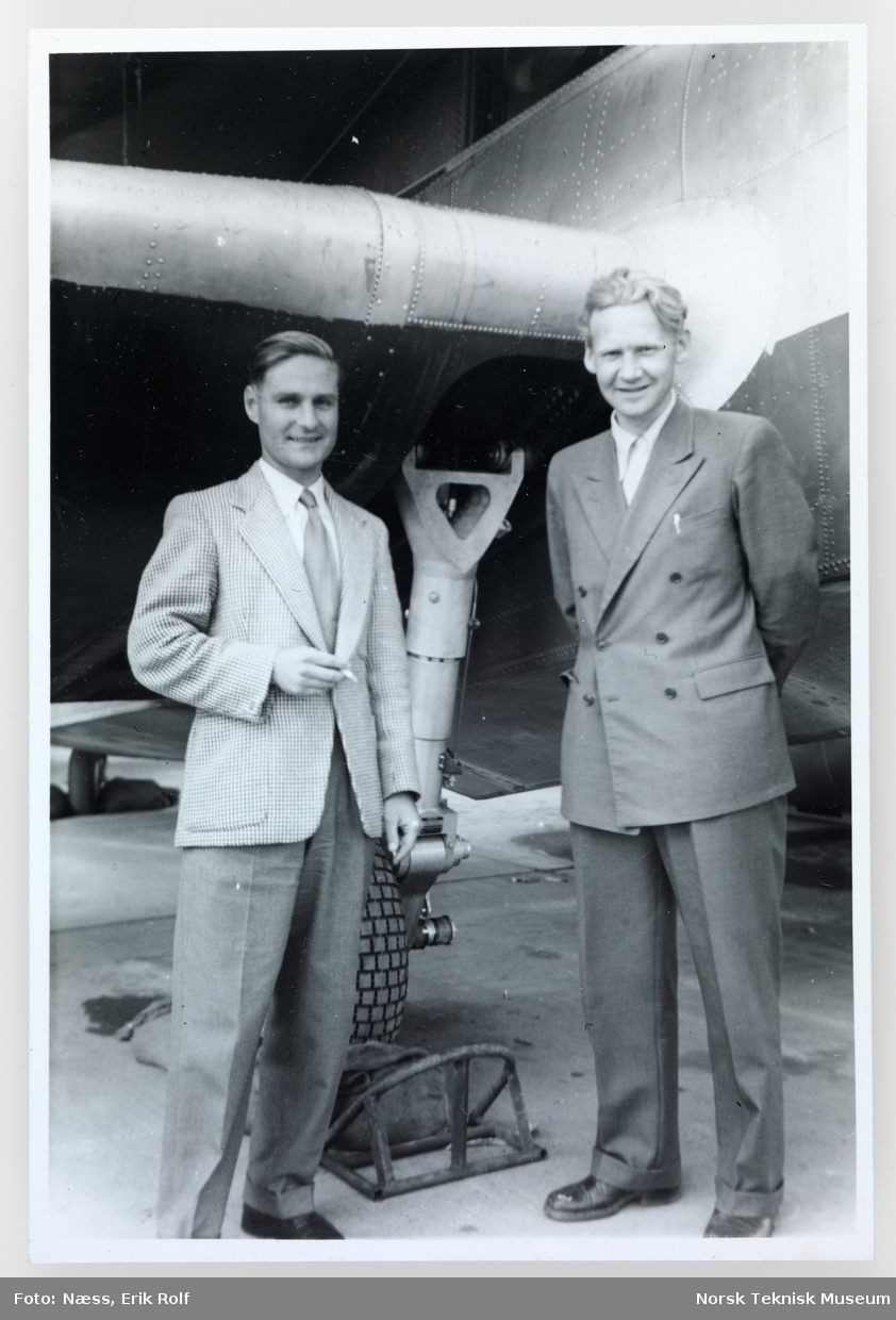 To menn står foran et fly.