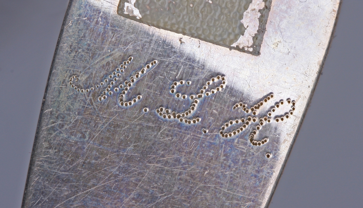 Enkel strek langs kanten av skaftet.