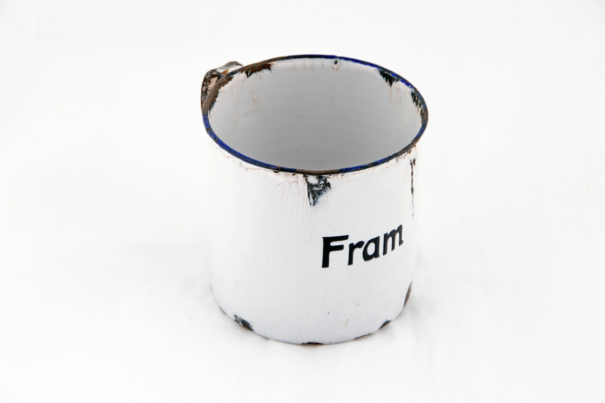 En hvit emaljert kopp med blå rand rundt drikkekanten. På koppen står det "fram" i svart.
