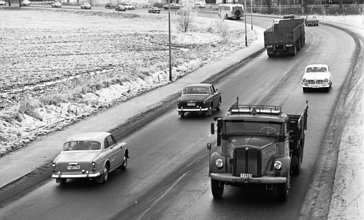 Länsläkaren, Trafiken 24 december 1966

Ett antal bilar, lastbilar och en buss kör på en gata. Det ligger snö på marken.