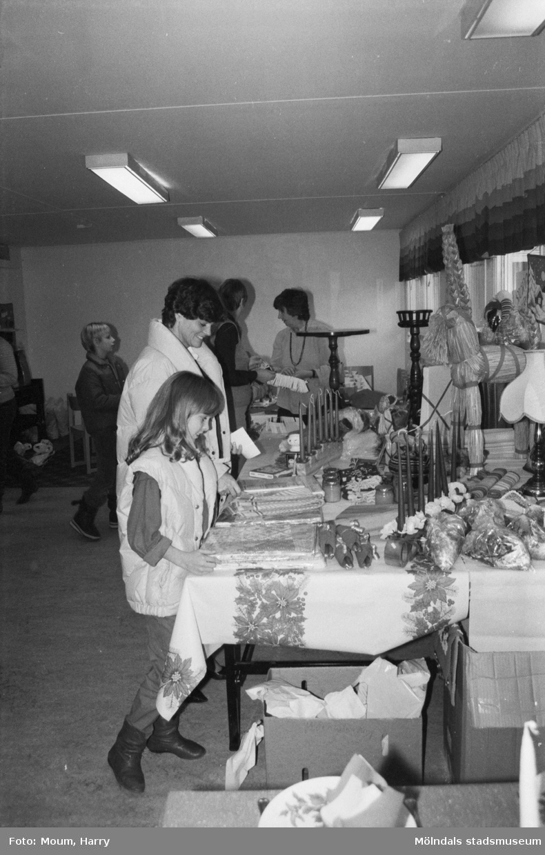 Lotteri och försäljning i Sankt Johanneskyrkan vid Sagbrovägen i Lindome, år 1983. "Mona och Pia Mattsson kollar in vinsterna."

För mer information om bilden se under tilläggsinformation.
