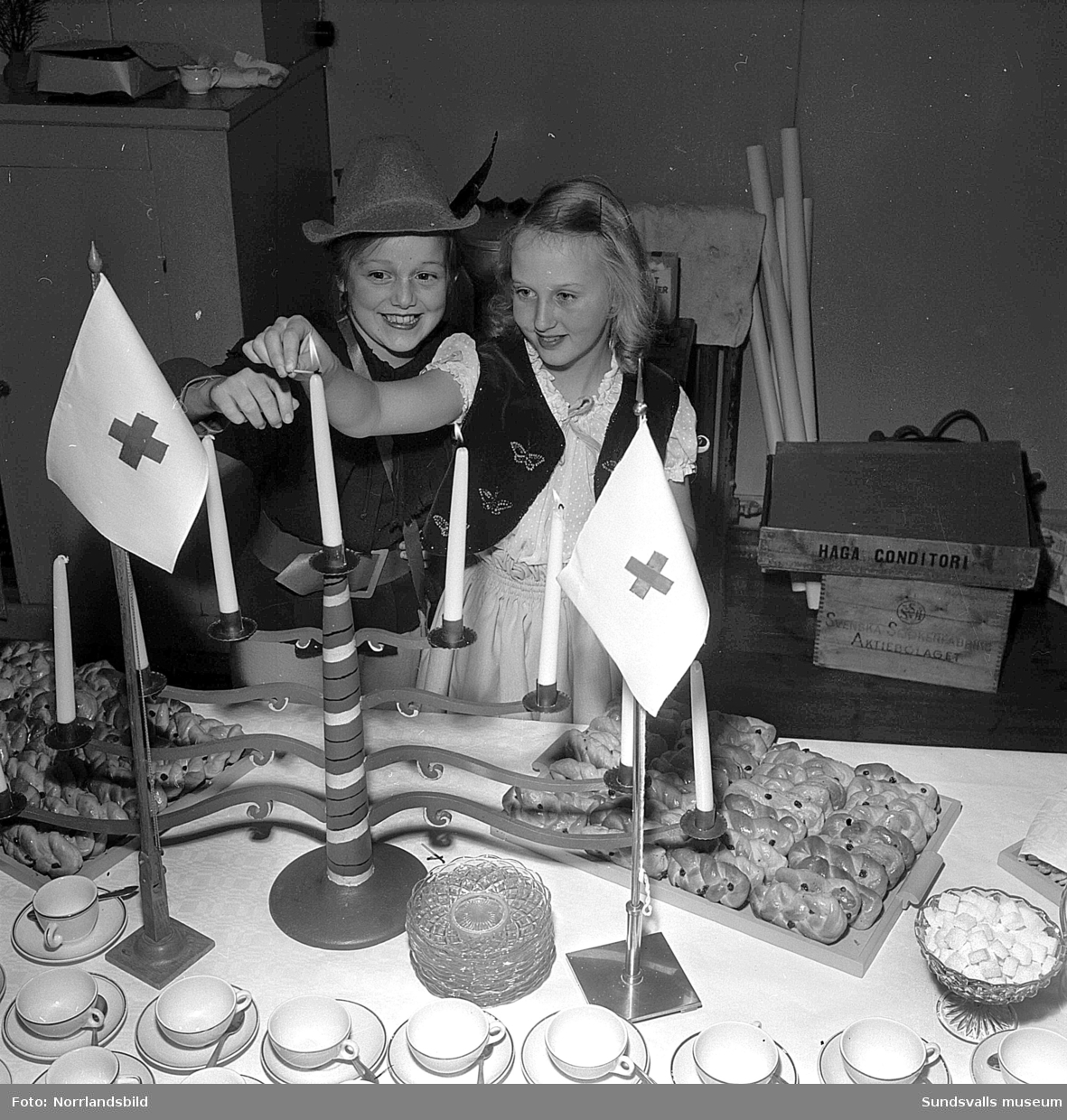 Jägaren och Snövit var en del av en dansföreställning på Röda korsets luciasoaré i Skönsbergs gamla folkets hus. På första blden är det Laila Sundesson och Marianne Rydberg som hjälps åt att tända ljusen på kaffebordet.