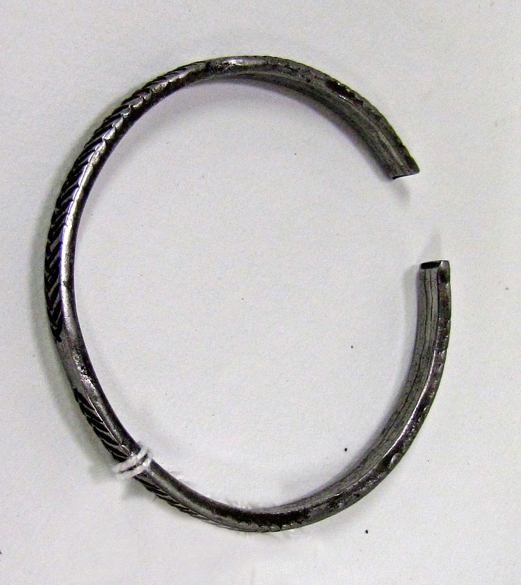 Ett av sex öppna armband av järn med räfflor och däremellan släta stycken. Armbandet är 5,5 cm brett och 0,5 cm tjock. Utan etikettnummer, dock vidhängande bricka med troligen "M" . Enligt senare funnen förteckning M= sex armringar av stål. ( katalog 6. ) Gåva av Eriksson. ( den 7/3 68. )

Föremålet tillhör den etnografiska samlingen.