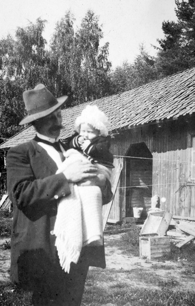 Trolldalen under øvre Tomter (?)(60/1). Kan være Martin Larsen som var husmann i Trolldalen fra 1903. Barn på armen