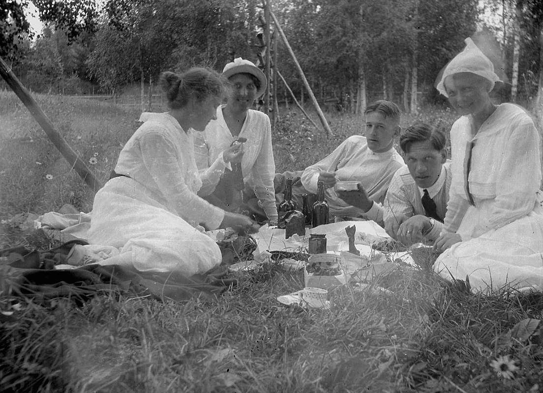 Grupp fem personer i gräset, picknick.
Karl Hedström
Dalarna.