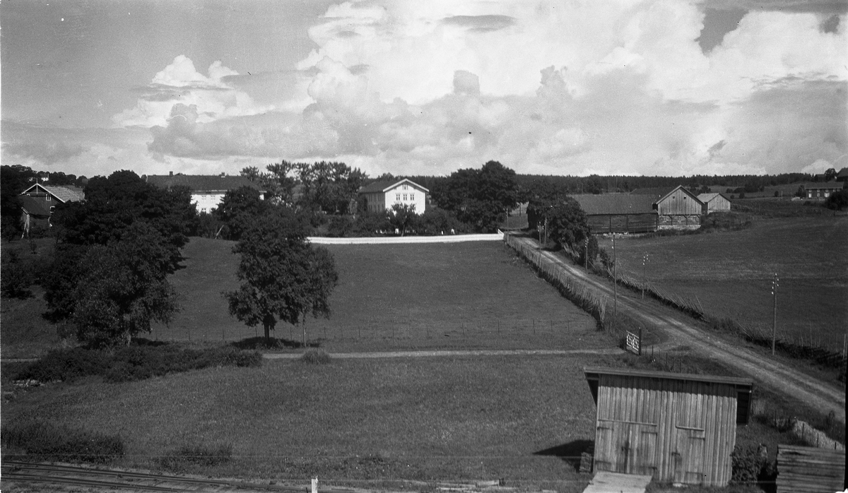 Utsikt mot gårdene Kraby Østre og Vestre, Østre Toten, juli 1925.
I høyre bildekant kan man se Hoff Arbeidersamfunn.