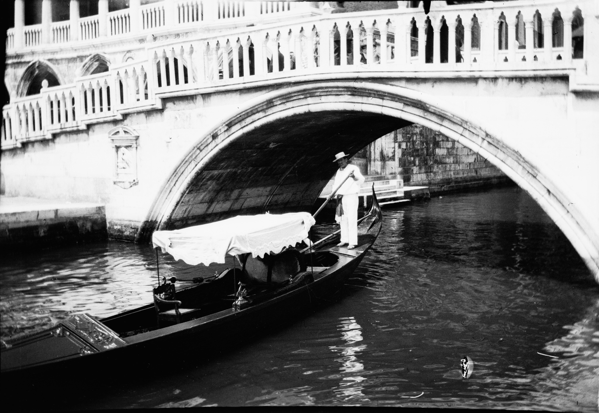 Drottning Victoria bilder. Man i gondol under Ponte della Paglia invid Markusplatsen i Venedig.