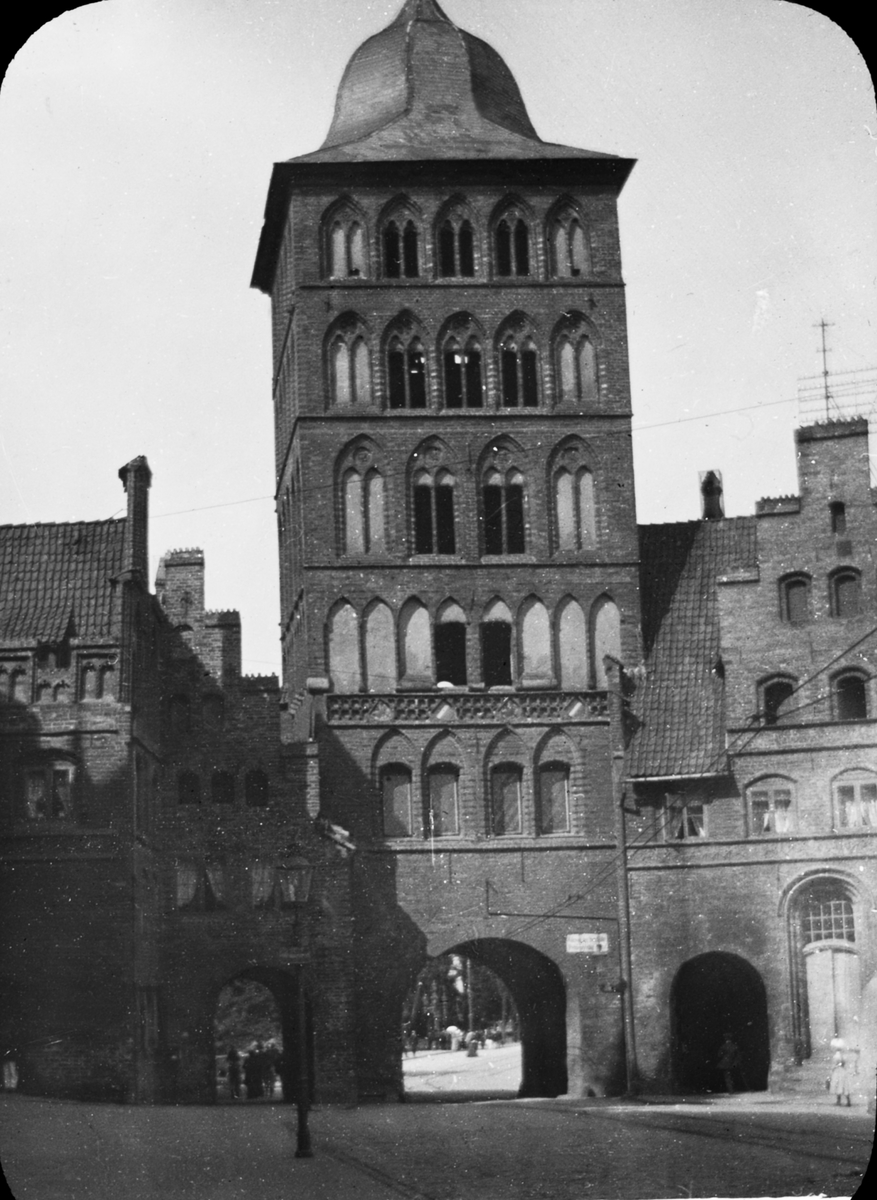 Skioptikonbild med motiv av Lübeck Burgtor, port i stadsmuren, Lübeck.
Bilden har förvarats i kartong märkt: Lybeck 1901.