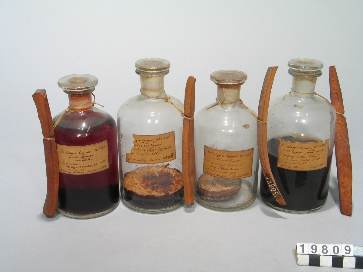 En samling prover från en serieundersökning över garvämnens av olika sammansättning på olika hudar vid dessas förvandling till läder. Provarna bestå av bark, garvämnesextrakt i flaskor av glas och garvade hudar med etiketter, signerade Landin 1884.
