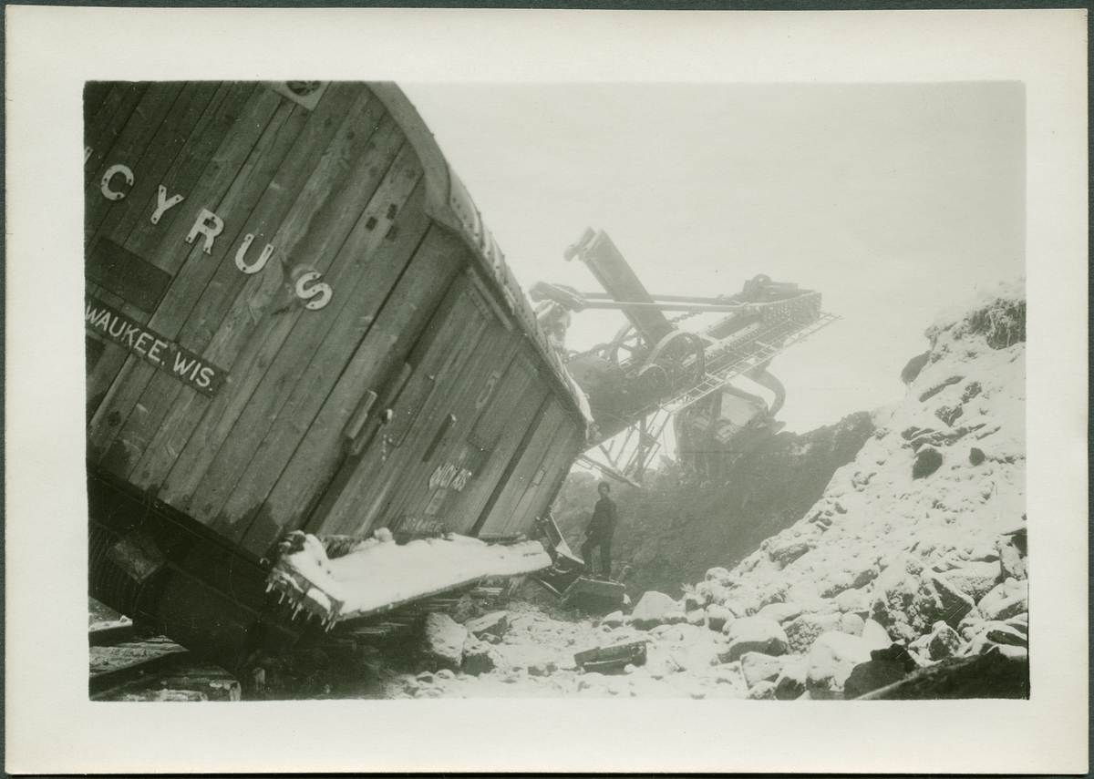 Grävskopa med lyftkran på lut vid gruvan i Kiruna. På bildens baksida står det Gustaf Horn.