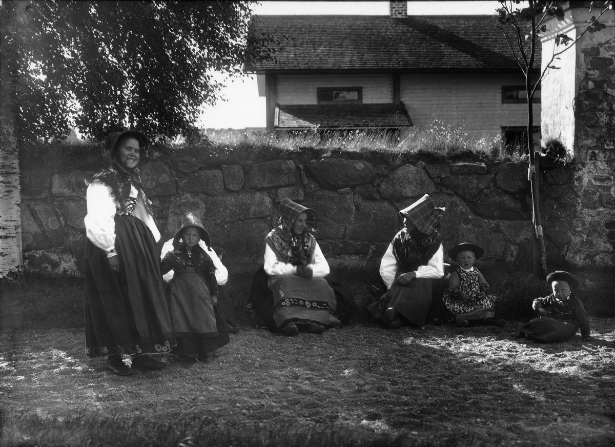 Diapostiv, fönsterbild med motiv från Floda. Fyra kvinnor (kullor) med tre barn, i traditionsenlig däkt.