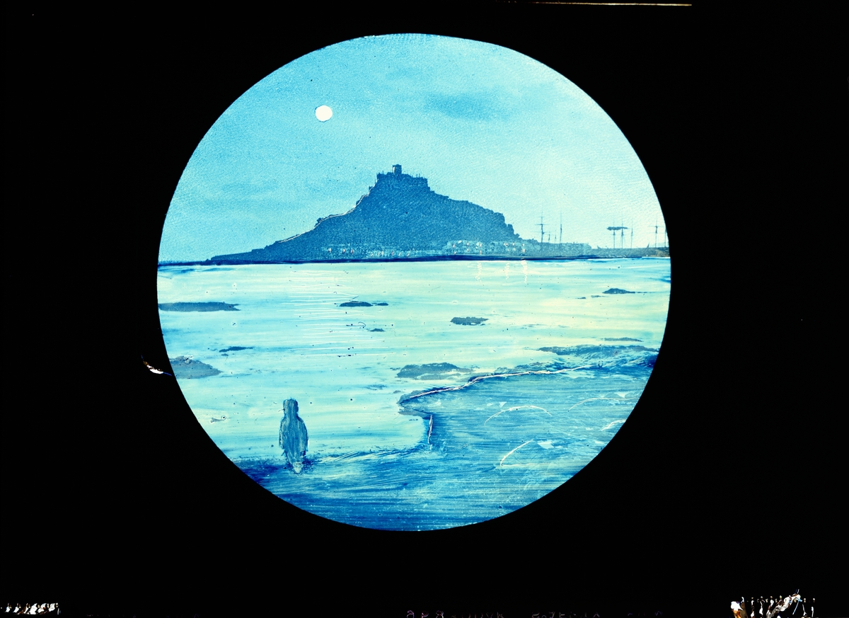 Skioptikon målad i färg på glasskiva.
Hamnstad i  månljus sett från strand på andra sidan vattnet.
