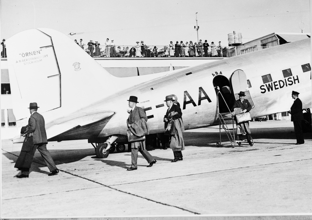 Flygpassagerare från London anländer till Bromma flygfält med ett av ABA:s Douglasplan (DC-3).