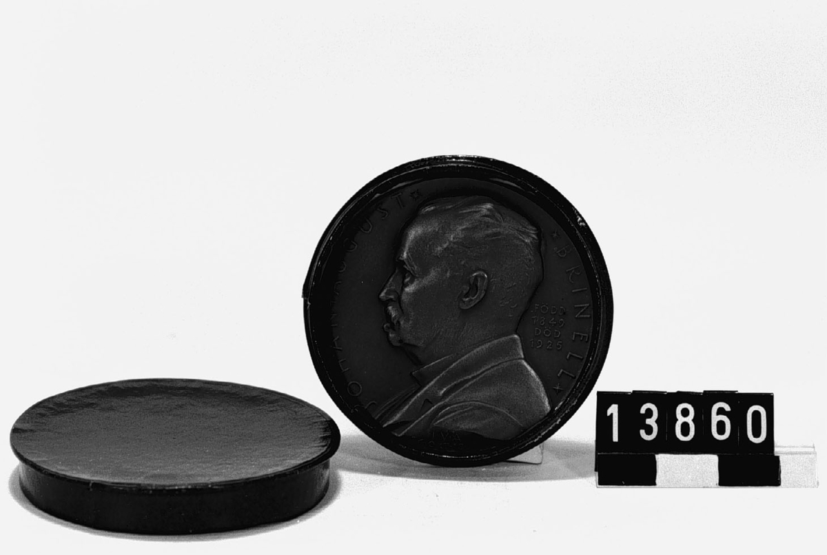 Medalj i brons över Johan Aug. Brinell, f. 1849, d. 1925. Signerad E L. Slagen av I.V.A till dess högtidssammankomst den 24 okt. 1937. Tjocklek 4 mm. Åtsidan: Porträtt, vänster profil, av Brinell med text runtom. Frånsidan: Prometeus-figur.