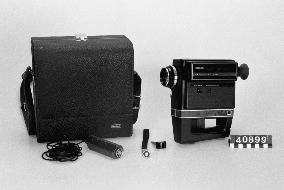 Ljudfilmkamera Super 8, Kodak Ektasound 140, med väska som innehåller mikrofon, stativ och handledsrem. 200 mm objektiv 9-21 mm. Kodak Ektar 200 mm. Inbyggd exponeringsmätare som automatiskt ställer in rätt bländare. Den inbyggda ljudupptagningen justeras också automatiskt.
Tillbehör: Väska med mikrofon, stativ och handledsrem.