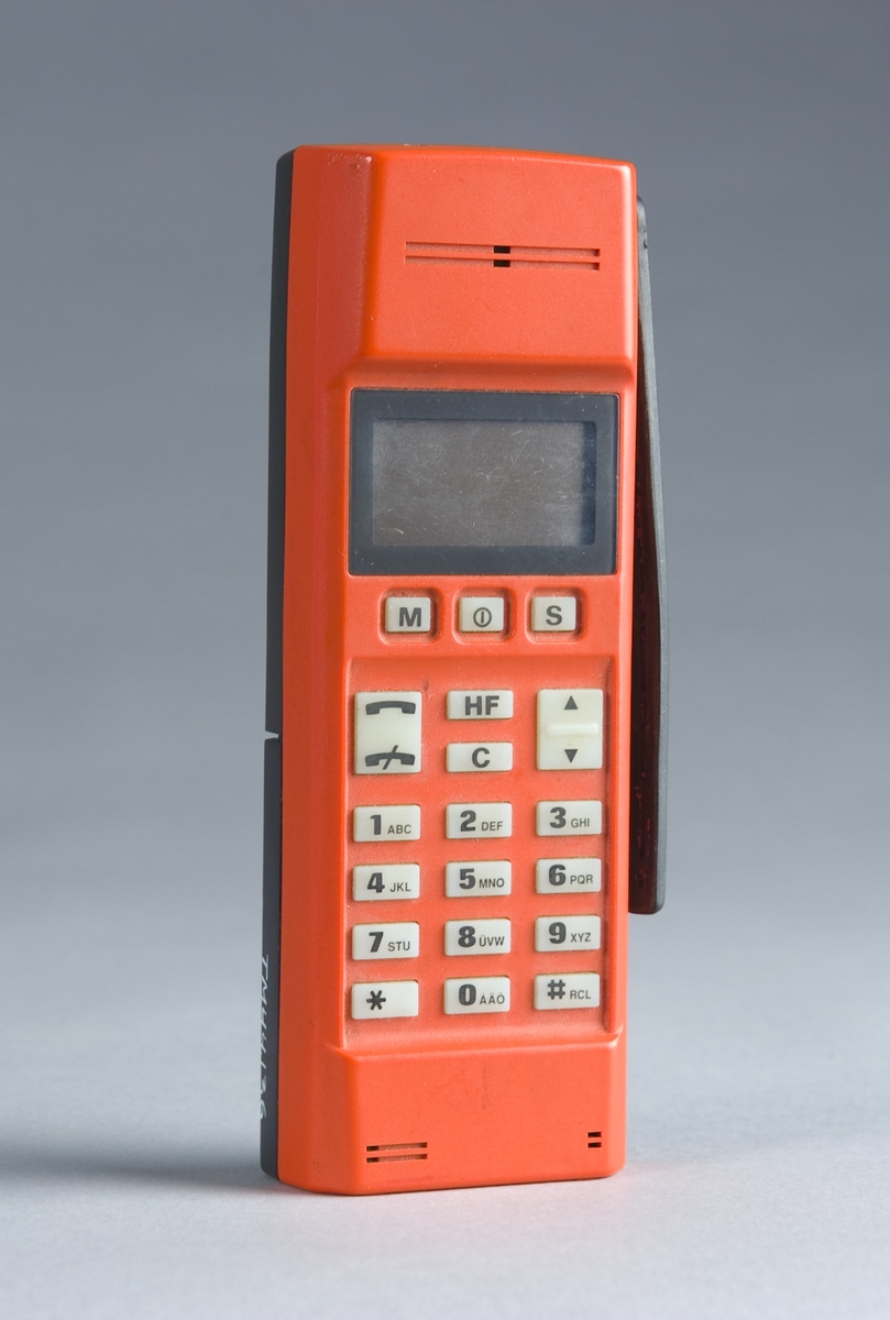 Handhållen NMT 900 mobiltelefon. Demoexemplar, färgförslag i röd kulör, med Nickel-Cadmiumbatteri märkt: 95/11. Ej i produktion.