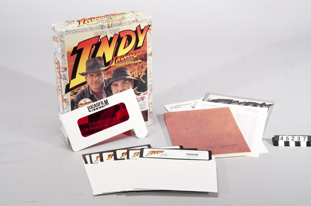 Indiana Jones and the Last Crusade: The Graphic Adventure. Datorspel för PC. Spelet är förpackat i en ask och omfattar sex stycken floppydisketter. Medföljer gör även manual, en översättnignstabell, samt en bok med bilagor till spelet. Spelet är ett äventyrsspel som spelas i tredjeperson perspektiv och är inriktat på problemlösning med vissa actioninslag.  För PC, XT, AT, PS/2, Tandy