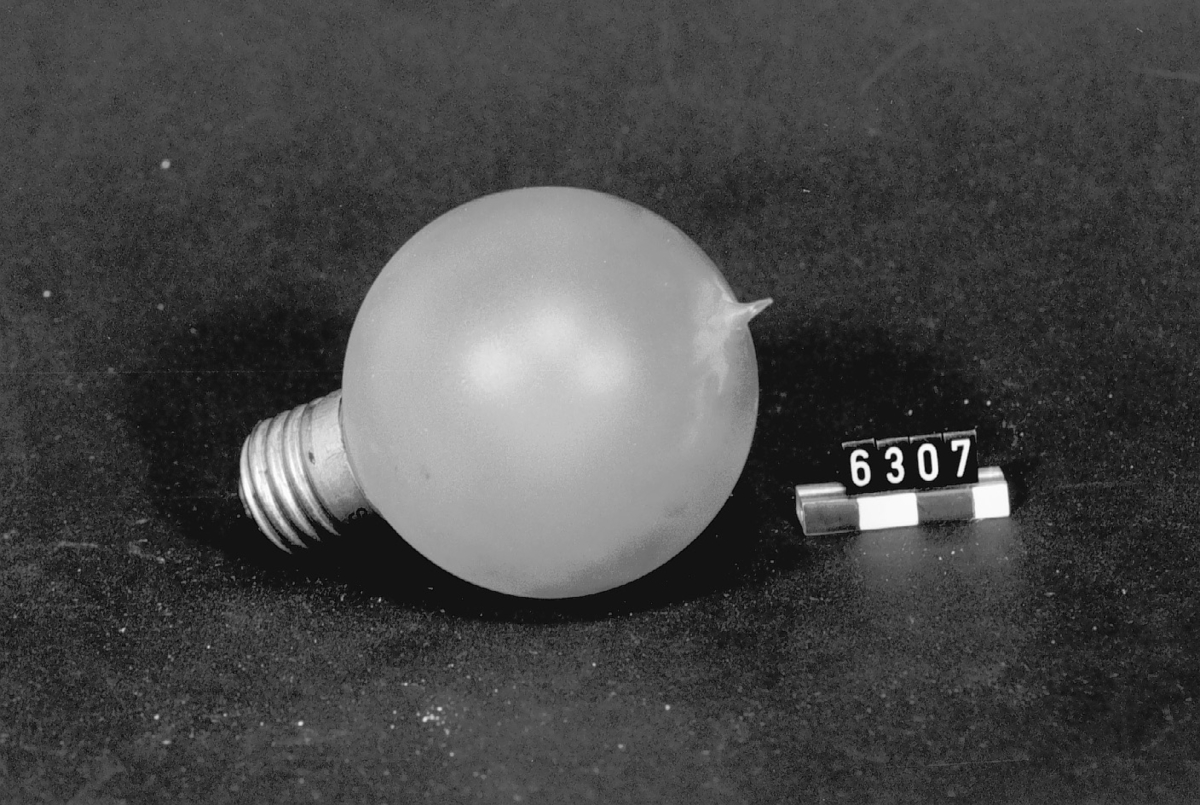 Elektrisk koltrådslampa med normalfattning, klotform, yttermatterad. 220 volt, 16 normalljus. Märkt på fattningen: "220 16 S.G.N.".