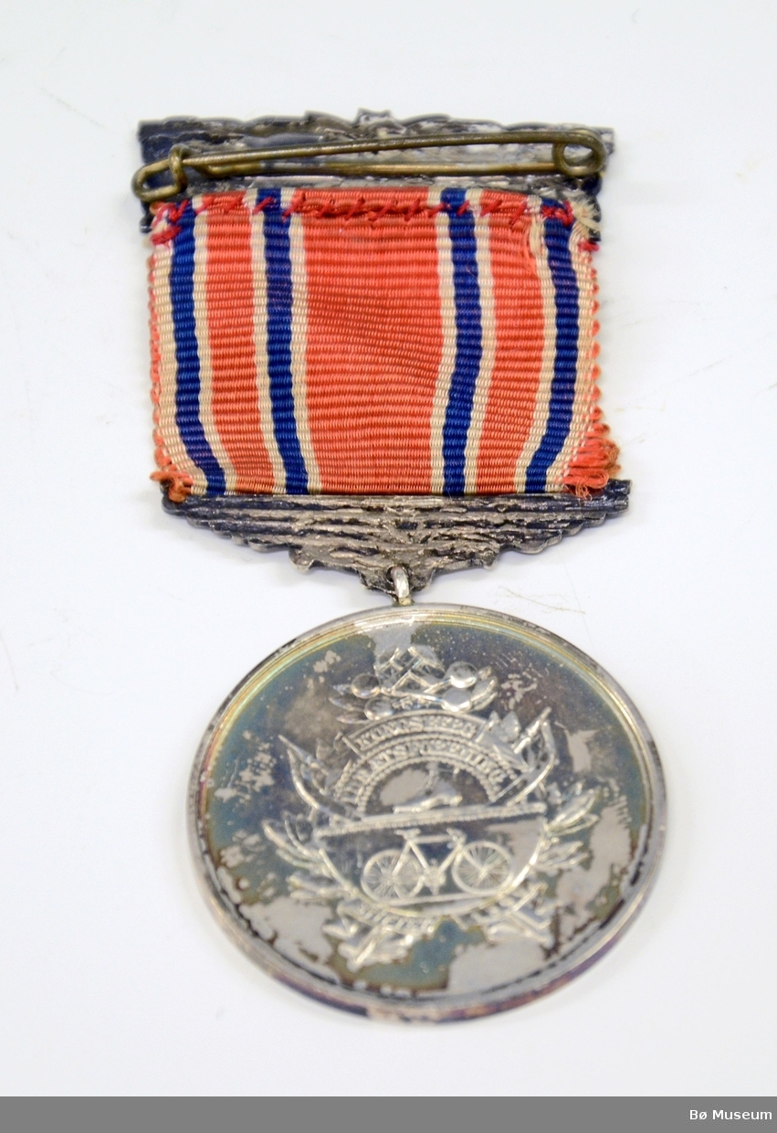 Medalje (ant. deltakermedalje) med innskrift:
"IDRÆT GIVER SUNDHED" (på framsiden)
"KONGSBERG IDRETSFORENING" (på baksiden)
Bånd i det norske flaggets farger - sterkt falmet.