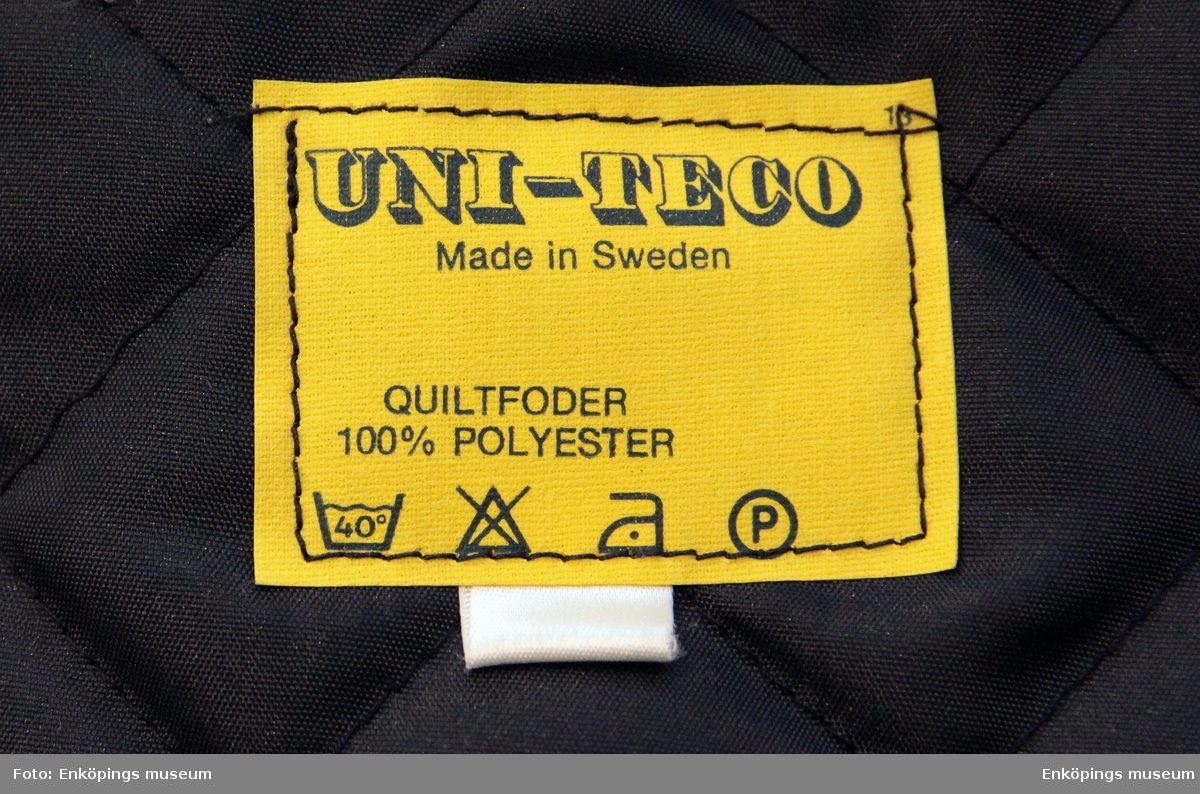 Polisrock med avtagbart foder  C100% polyester. Har en avtagbar krage av får- päls.
Tillverkad hos Uni- teco, Sverige 1976.
