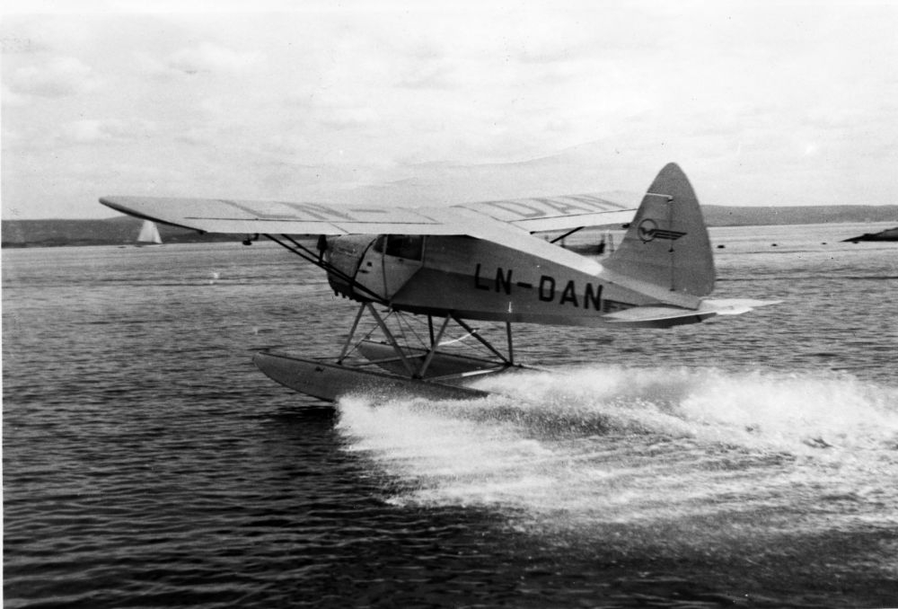Landskap. Et sjøfly, LN-DAN,  av typen S.A.I. KZ fra Widerøe i ferd med å lette/lande.
