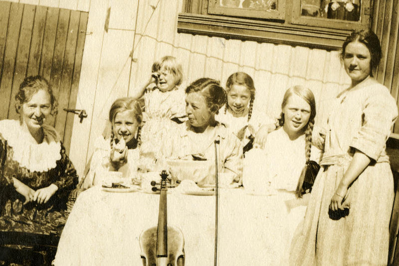 To damer og fem jenter i forskjellig alder oppstilt for fotografen. (Foto/Photo)