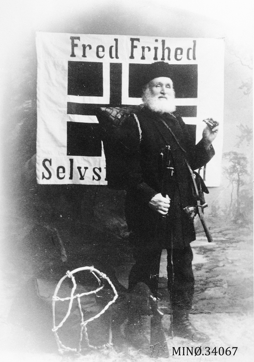 Mann foran banner hvor det står "Fred, Frihed og Selvstendighed"