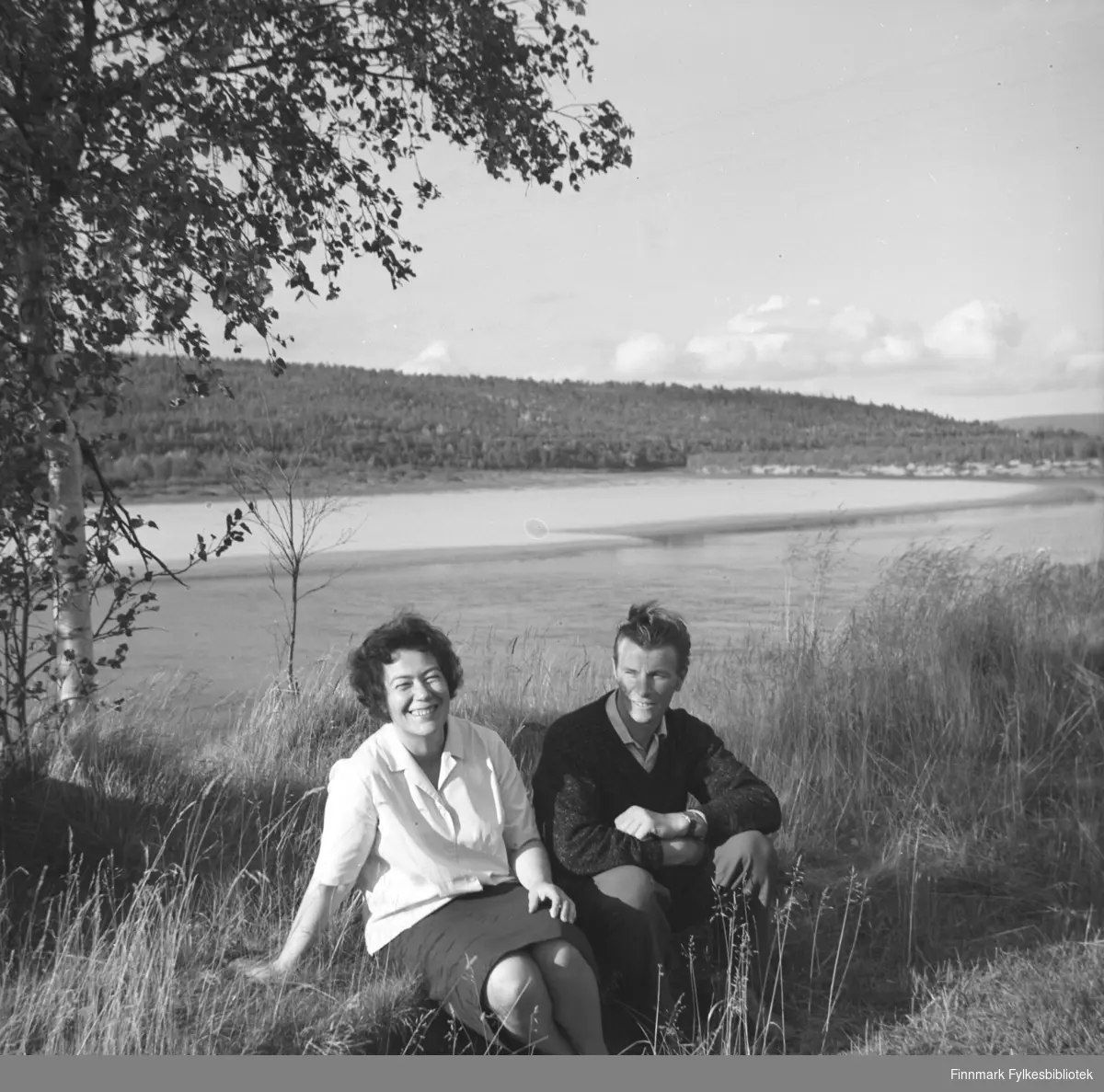 Jenny og Eino Drannem sitter ved bredden av Neidenelva.
