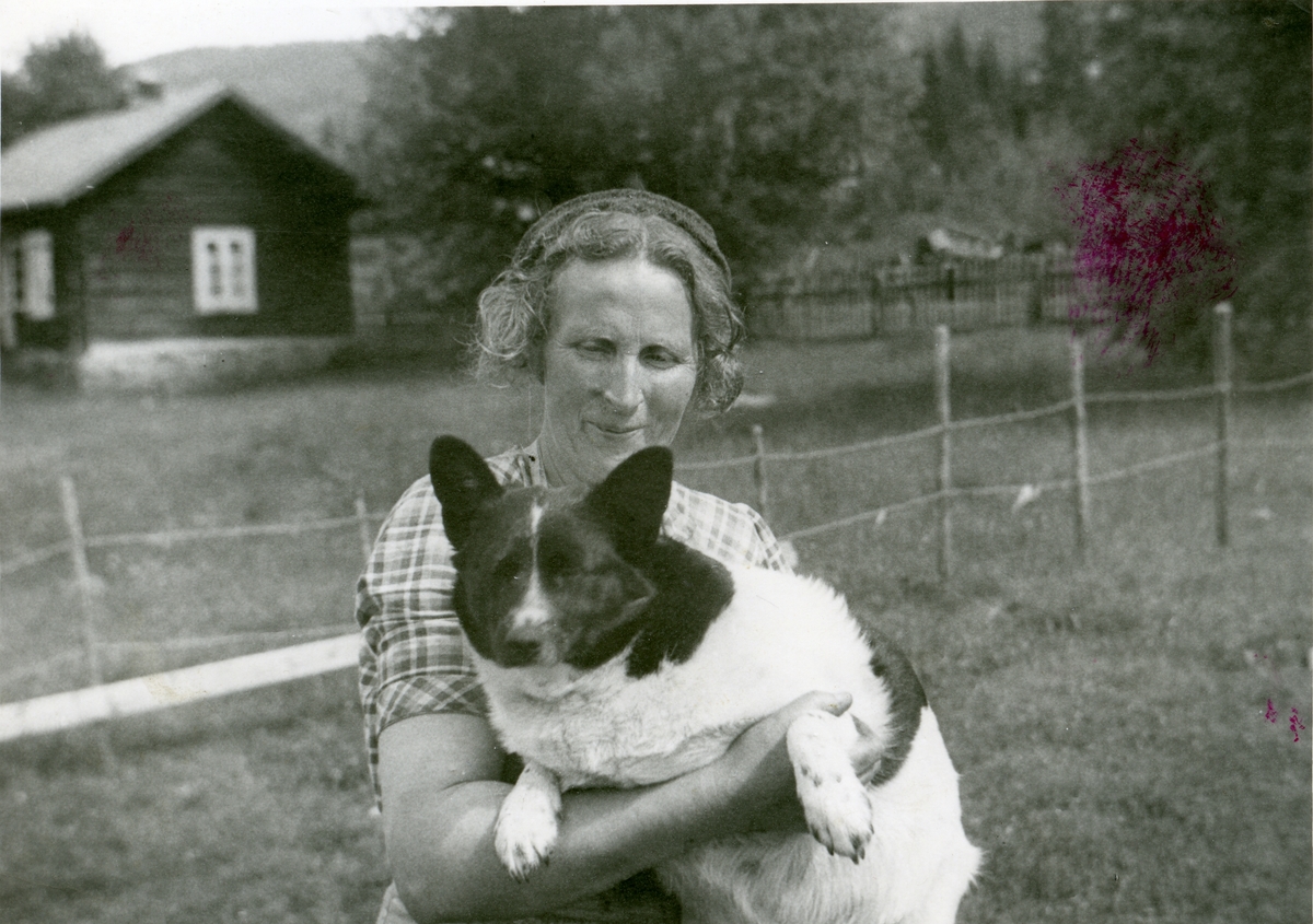 Marie Brager fotografert sammen med sin hund i hagen.