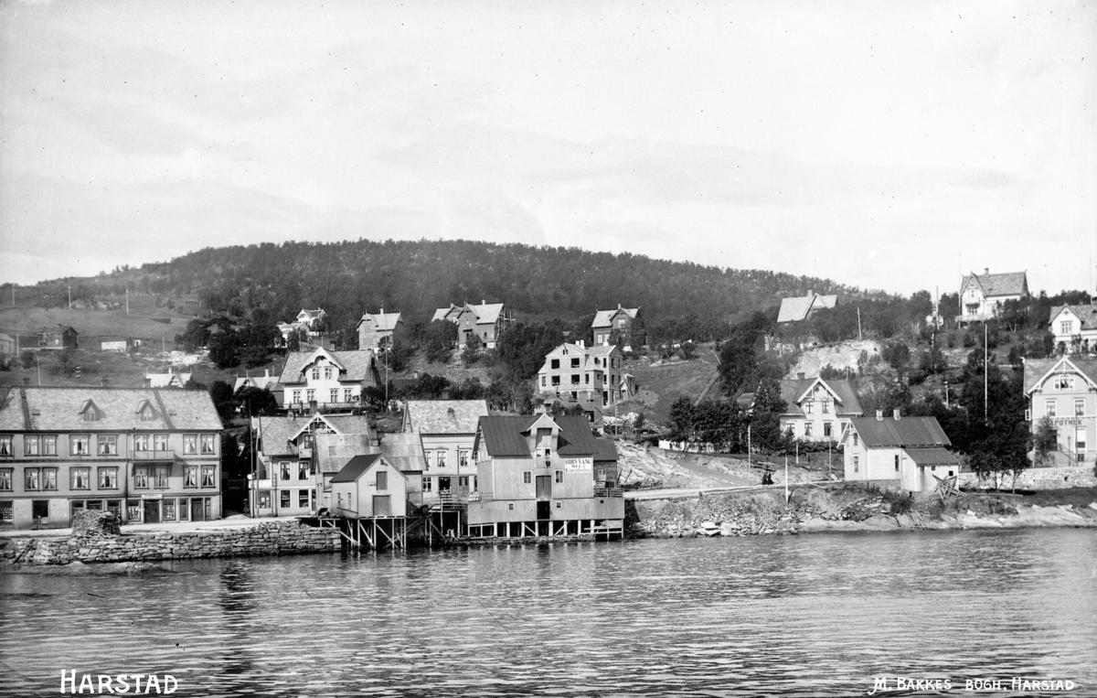 Bebyggelse langs Strandgata, fotografert fra Harstadsjøen.