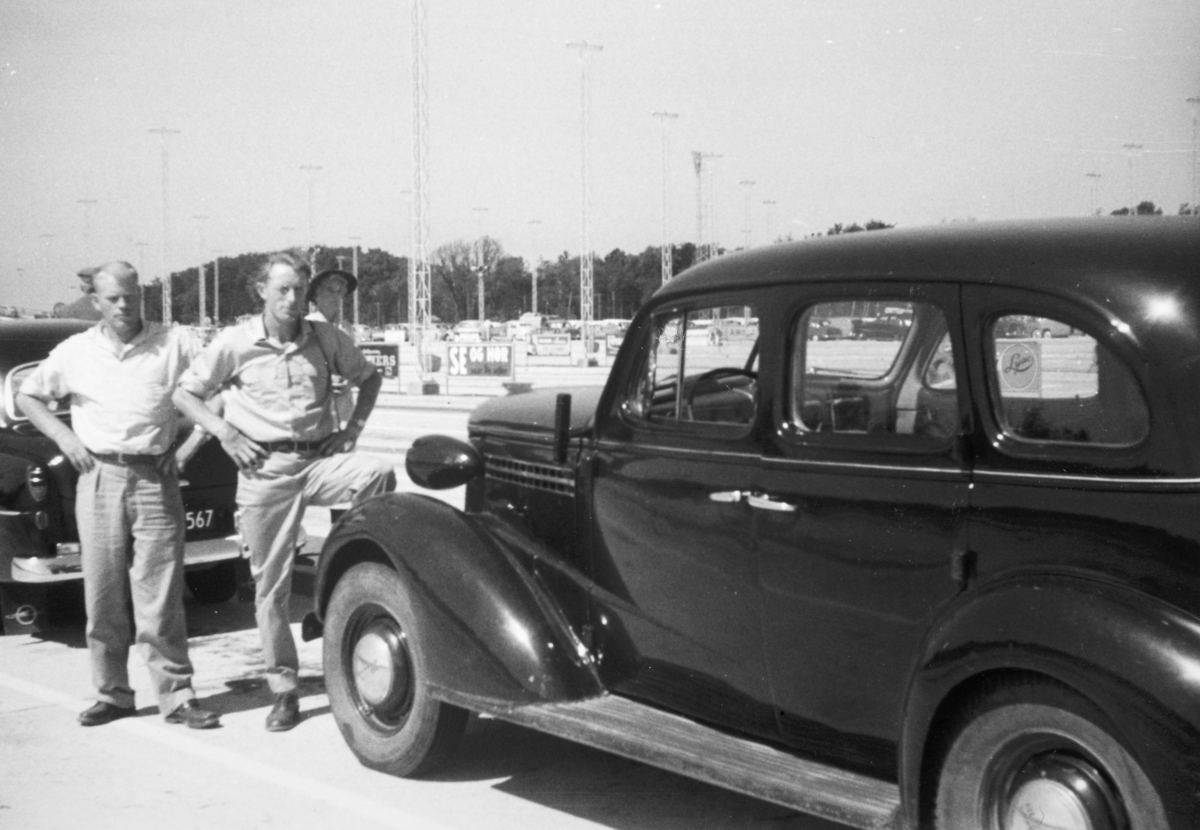 F.v Magnus Lystad, Trygve Svestad fra Ottestad, personbil. Chevrolet 1938 nærmest, Opel Rekord tidligst 1953 skimtes. Ca.1953-1954.