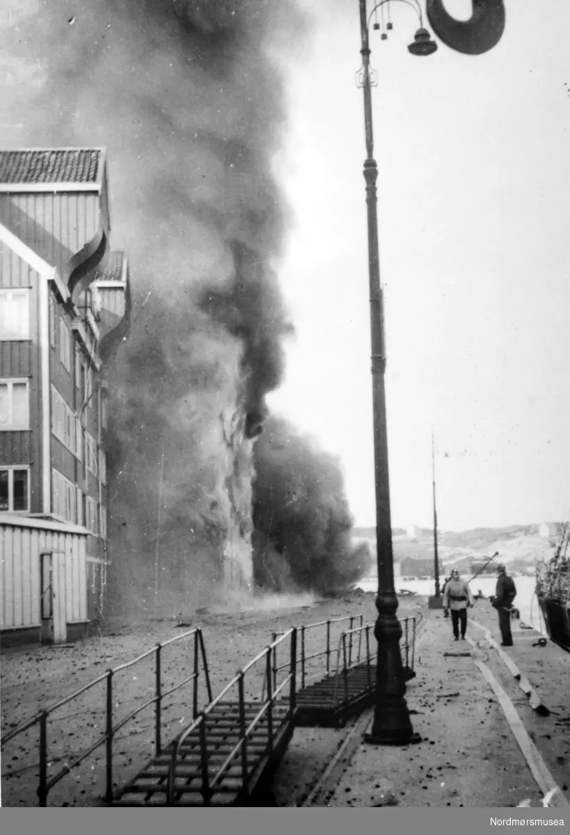 Andre verdenskrig har nettopp kommet til Kristiansund. Datoen er rundt 28. april 1940, og vi ser her hus på Storkaia som brenner. Fra Nordmøre Museums fotosamlinger.

