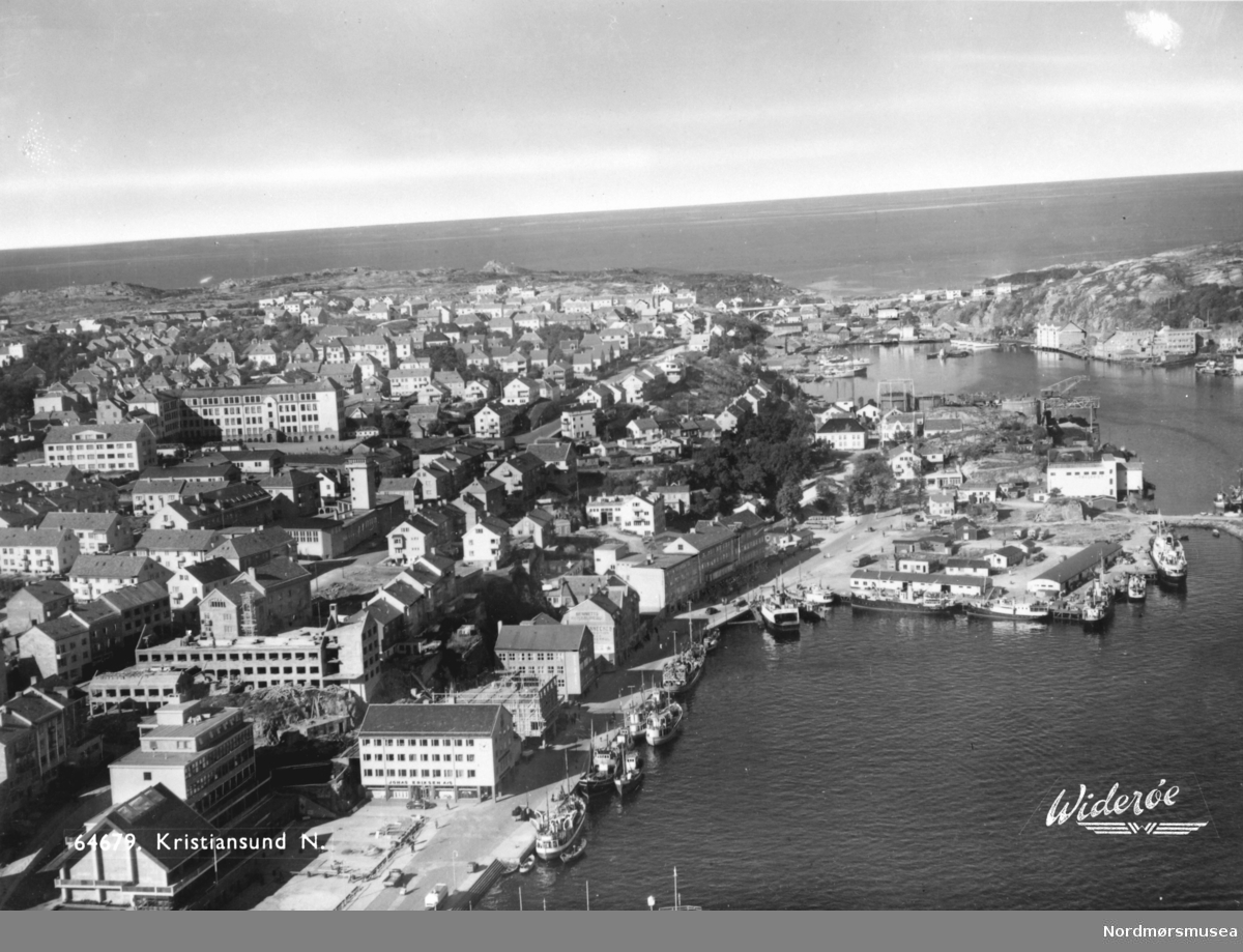 Foto fra Vågekaia/Vågeveien, Johnsenhuken, Nordmørskaia og litt av Devoldholmen med Vågen og Gomalandet i bakgrunnen på høyre side. Datering er ukjent, men trolig omkring 1947 til 1969. Fra Nordmøre Museums samlinger. Reg: EFR
