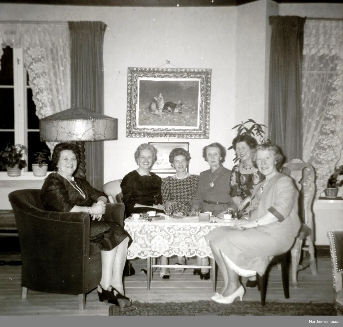 En gruppe kvinner samlet til selskap, trolig i Kristiansund. Bildet er trolig tatt av Fasting mellom 1945 til 1965. Fotoserie. Fotografier gitt til Nordmøre Museum fra Kate og Kristian Fastings arvinger per 1986. Fra Nordmøre Museums fotosamlinger. EFR2015
