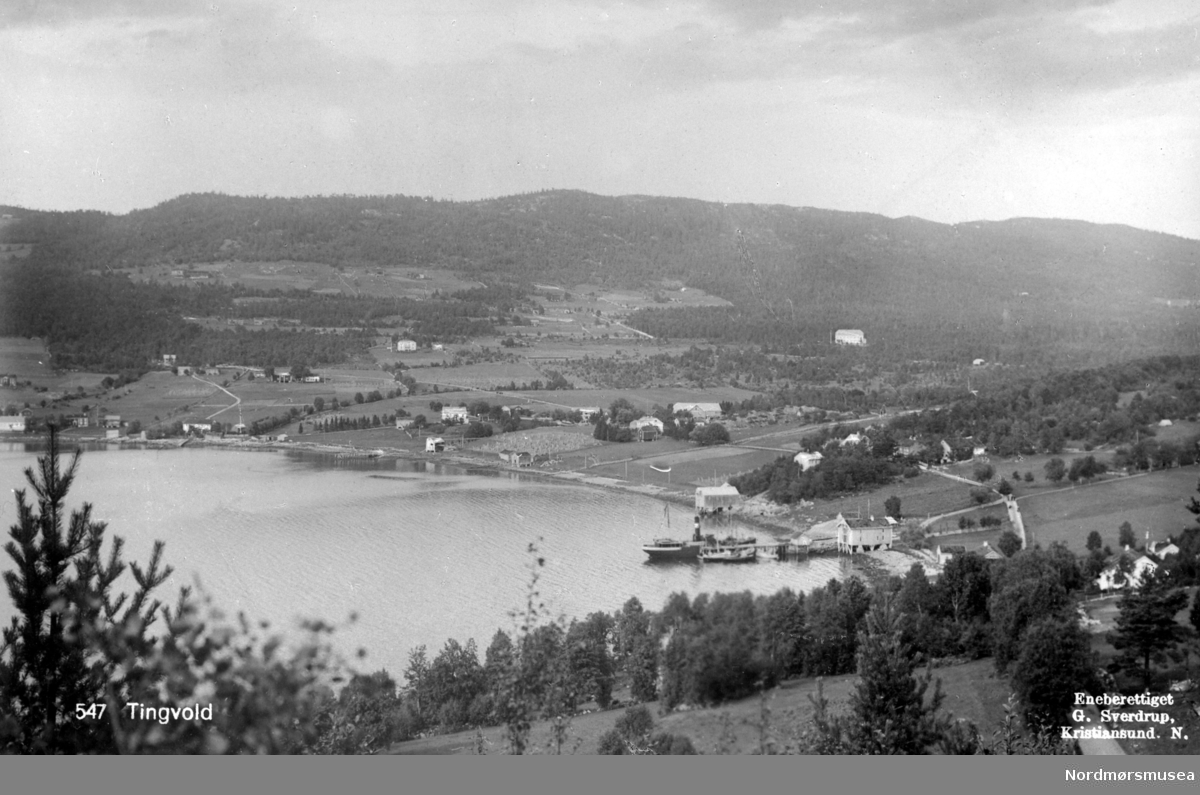 Et flott landskapsbilde med Tingvollfjorden og bygda Tingvoll som omkranser den, i Tingvoll kommune. Fra Nordmøre Museums fotosamlinger.
