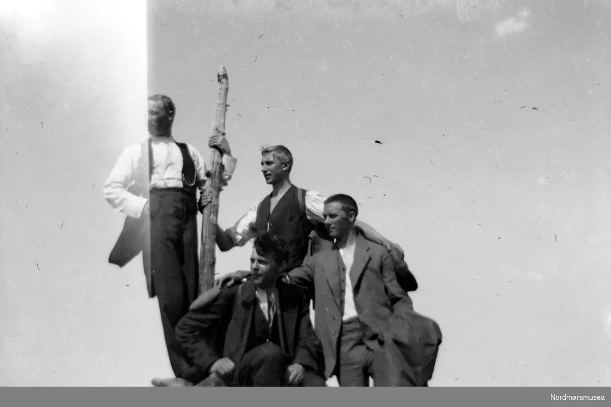 Gruppefoto av fire unge menn skuer ut i det fjerne. Fra Nordmøre museums fotosamlinger.